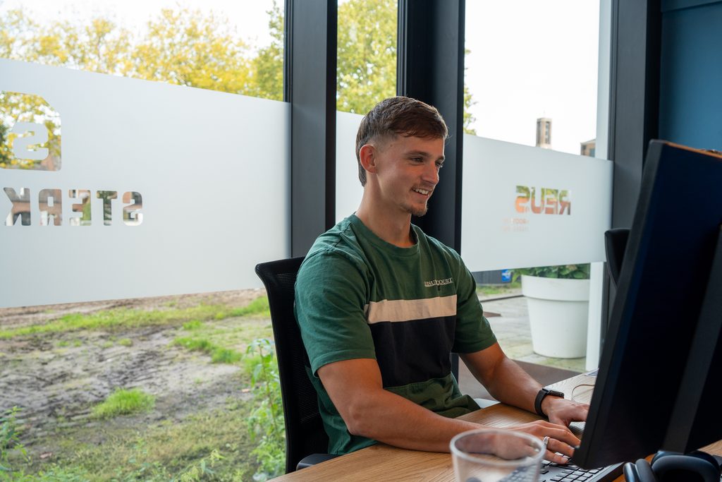 Een collega van REUS werkt aan branding voor een klant
