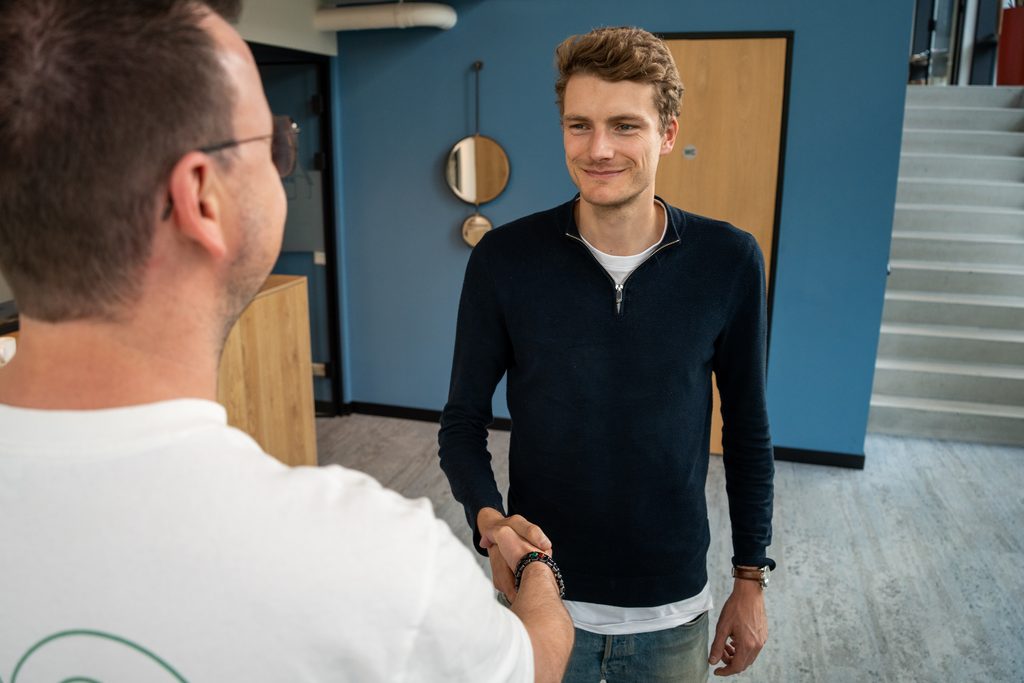 Een collega van REUS heet een gast welkom