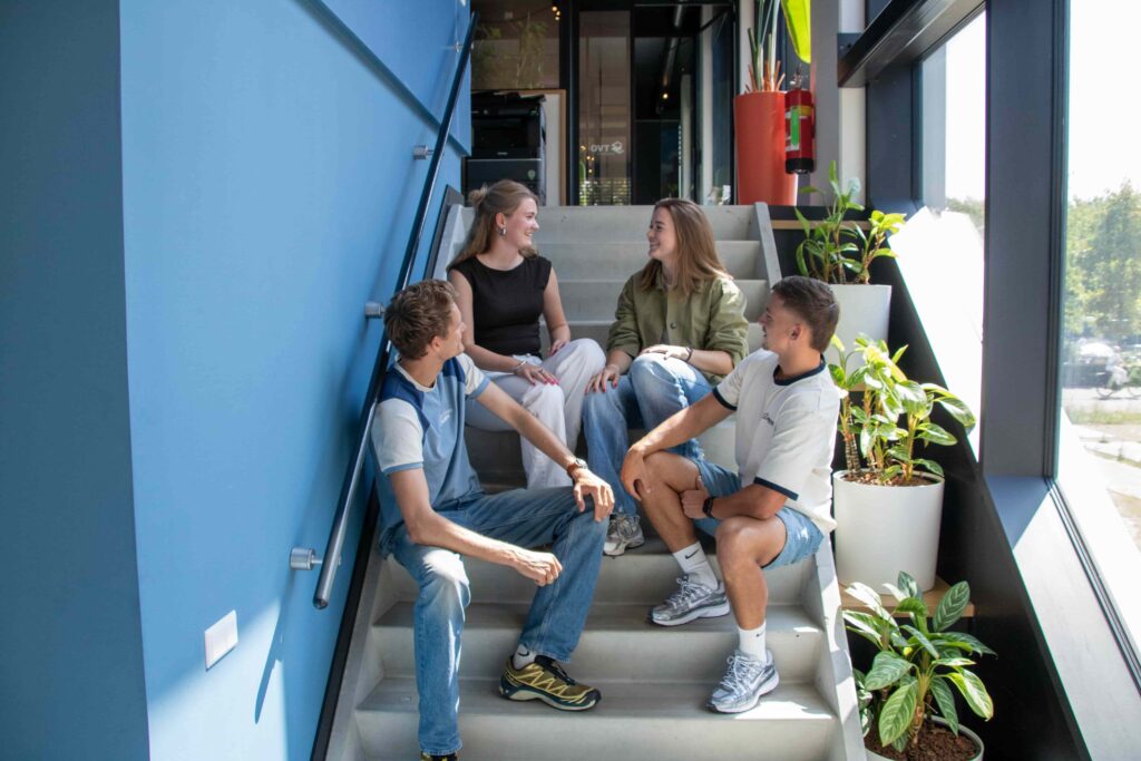 Collega's van REUS bespreken een e-mailcampagne op de trap