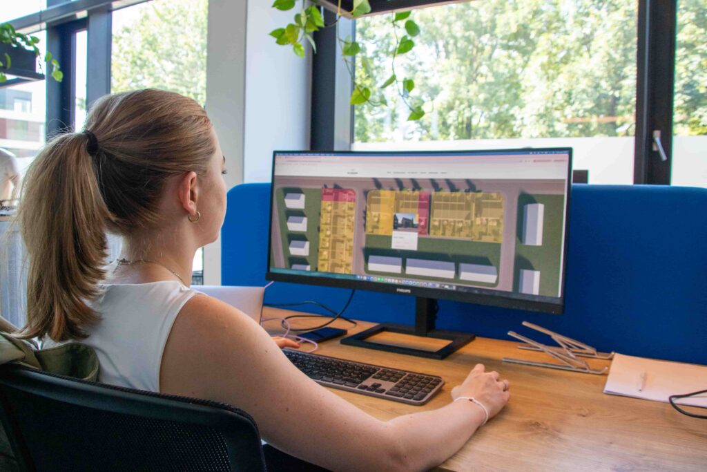 Een collega van REUS werkt aan een website op een groot scherm