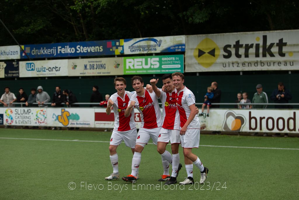 Spelers van Flevo Boys juichen voor het reclamebord van REUS