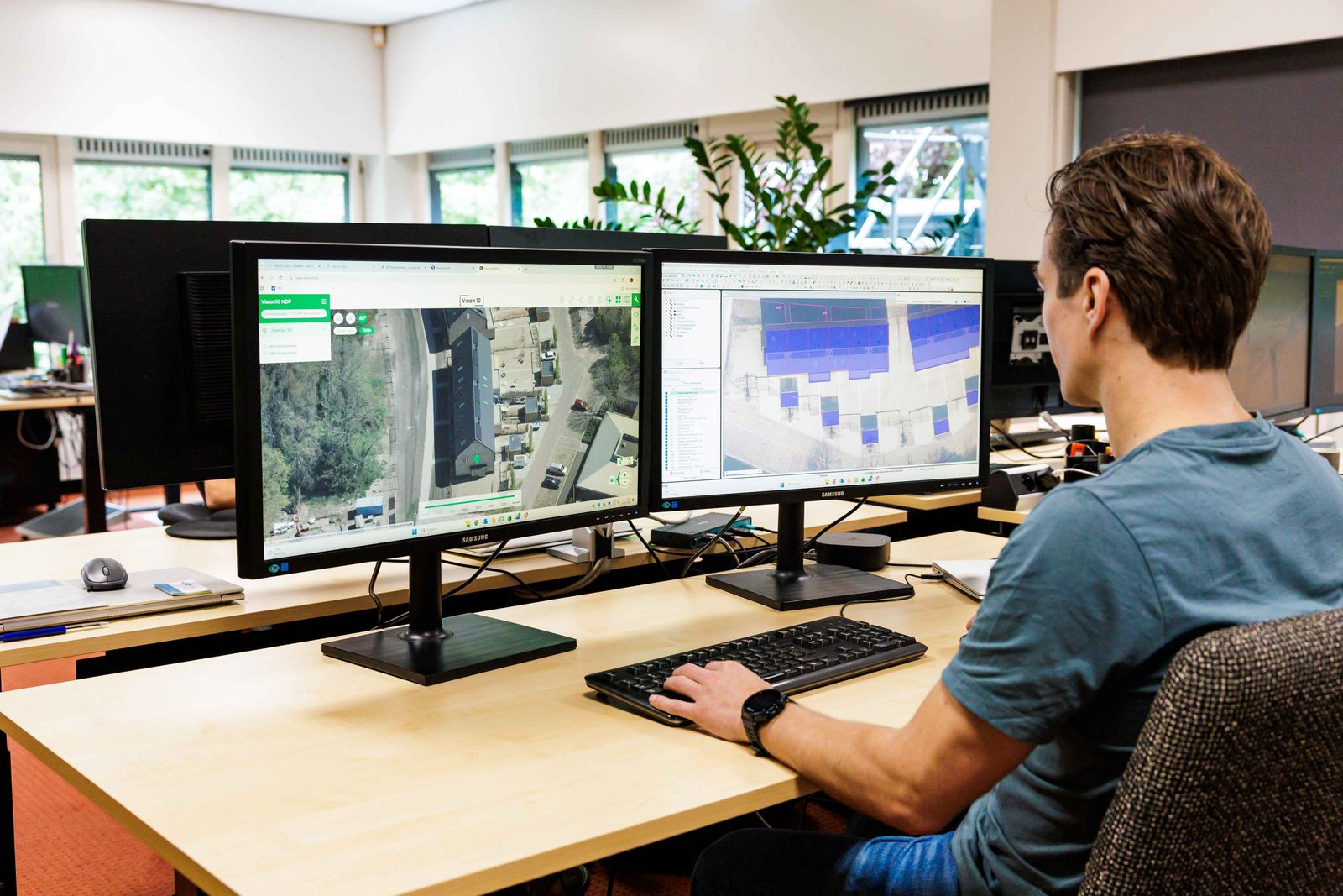 Medewerker van Facto Geo werkt met kaartmateriaal op kantoor