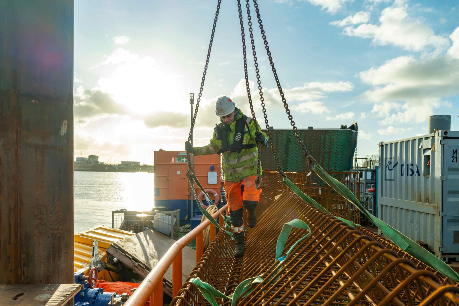 Bemanningslid van KW Trans Shipping aan het werk bij laagstaande zon
