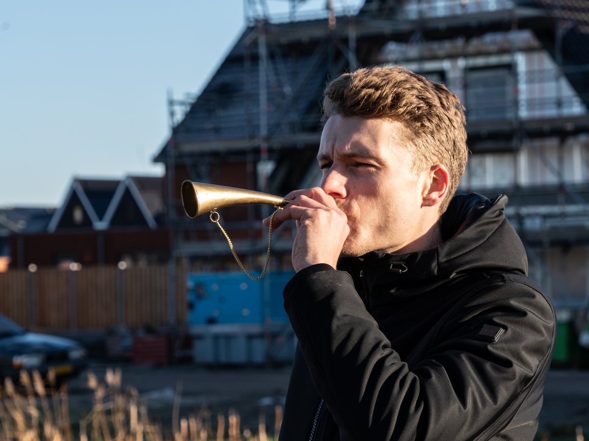 Man blaast op een toeter bij een nieuwbouwproject