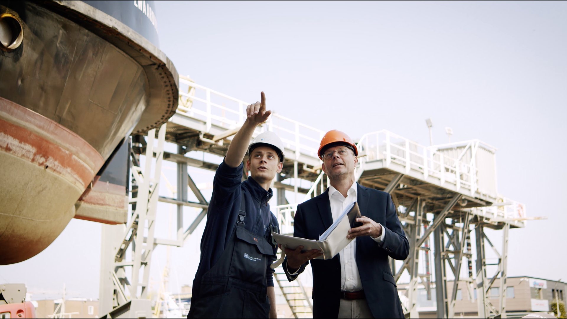 Still uit de brandfilm van Urk Maritime: twee mannen met bouwhelm op de werf