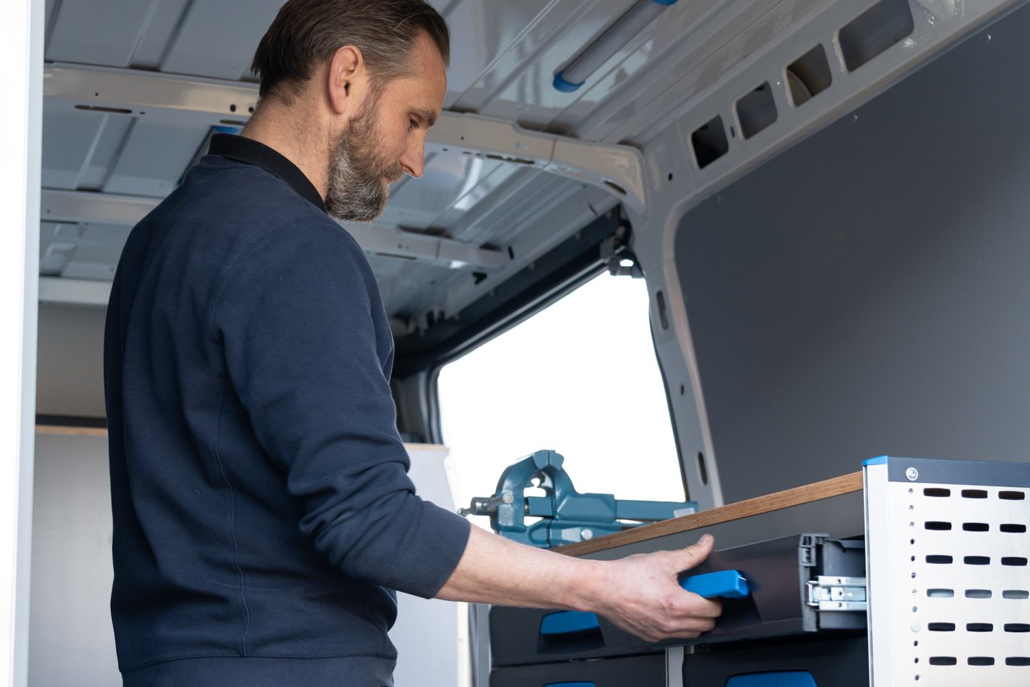 Medewerker van Verbeca trekt een lade open in een ingerichte bedrijfswagen